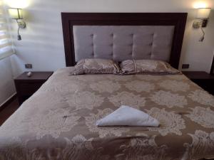 a bed with a pillow sitting on top of it at Hotel Begrand in Tapachula