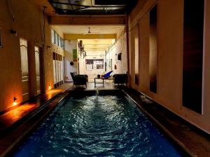 a swimming pool in a building with blue water at Hotel Begrand in Tapachula