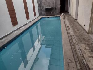 a swimming pool with blue tiles on the floor at Hotel Begrand in Tapachula +20 photos
