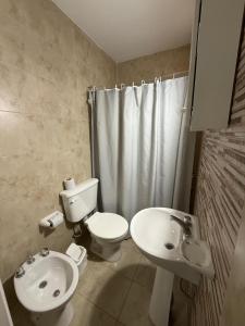 un baño con inodoro y lavabo en Continente Boutique, en San Clemente del Tuyú