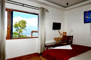 Телевизор и/или развлекательный центр в Hotel Valna Estate Himalyan View Kausani By HRG