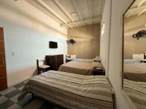 a hotel room with two beds and a mirror at Continente Boutique in San Clemente del Tuyú