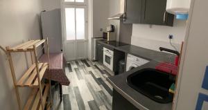 a small kitchen with a sink and a stove at Acacia 2 in Nevers
