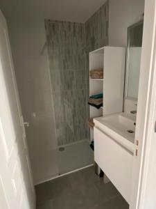 a white bathroom with a shower and a sink at Acacia 2 in Nevers