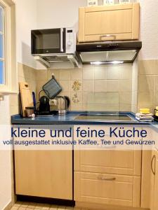 eine Küche mit Herd und Mikrowelle in der Unterkunft Heimathafen Dieksee in Malente