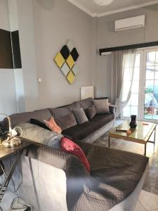 a living room with a couch and a table at jim villa family apartment with private yard andravida-kyllini in Andravída +8 photos