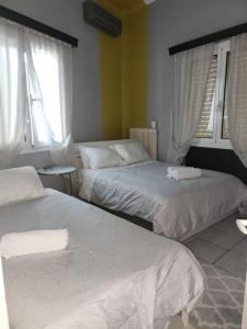 a bedroom with two beds and two windows at jim villa in Andravída