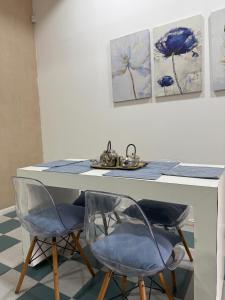 una mesa con 2 sillas y pinturas en la pared en Continente Boutique, en San Clemente del Tuyú