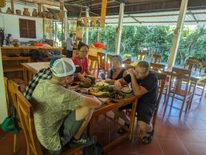 a group of people sitting around a table eating food at Mai Anh Garden in Soc Trang