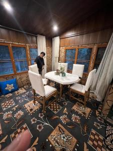 een man in een kamer met een tafel en stoelen bij Hotel royal resort in Srinagar +10 foto's