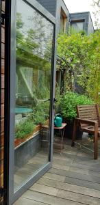 Una puerta corrediza de vidrio que da a un patio con un banco. en La Musicale, en Rouen