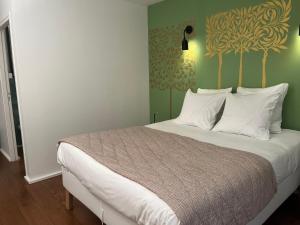 a bedroom with a large bed with white pillows at Denis & Virginie - château à pied - parking gratuit in Versailles