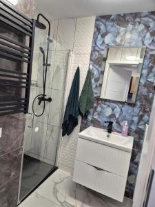 a bathroom with a shower and a sink and a mirror at Ostoja we Władku in Władysławowo
