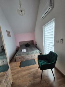 a bedroom with a bed and a chair in it at Ostoja we Władku in Władysławowo