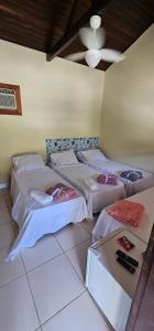 a room with three beds and a ceiling at Pousada Paraíso Guapi in Guapimirim