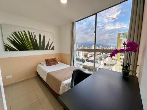 Un dormitorio con una cama y una mesa y una ventana. en Amoblados Casa de Pinos Bucaramanga, en Bucaramanga