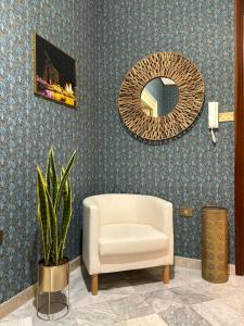 a living room with a chair and a mirror at Vintage Rooms in Palermo
