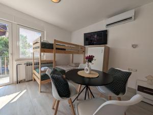 a room with a table and chairs and a bunk bed at Sesvete Studio 4 Four in Sesvete