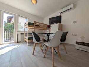a living room with a table and chairs and a bunk bed at Sesvete Studio 4 Four in Sesvete