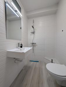 a white bathroom with a sink and a toilet at Sesvete Studio 4 Four in Sesvete