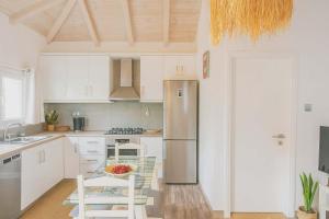 a kitchen with white cabinets and a stainless steel refrigerator at Secret Garden Volos in Volos