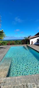 einen Pool mit blauem Wasser vor einem Haus in der Unterkunft OROKA EDEN in Ambondrona