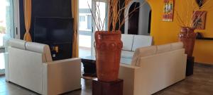 ein Wohnzimmer mit zwei weißen Stühlen und einer Vase in der Unterkunft OROKA EDEN in Ambondrona