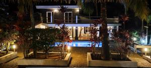 ein Hotel bei Nacht mit Palmen und einem Swimmingpool in der Unterkunft OROKA EDEN in Ambondrona + 22 Fotos