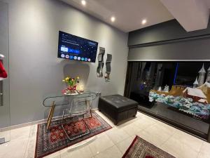 un soggiorno con tavolo e TV a parete di RIVER CITY Studio a Larisa