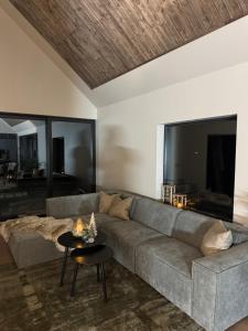 a living room with a gray couch and a table at LyNora Lodge 