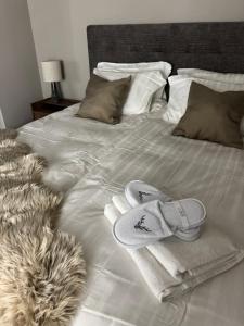 a bed with two towels and slippers on it at LyNora Lodge 