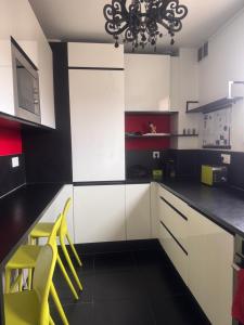 une cuisine avec des armoires blanches et des chaises jaunes dans l'établissement Atelier Couleurs - Evreux centre, à Évreux