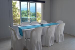 einen Konferenzraum mit einem Tisch und weißen Stühlen in der Unterkunft Finca el Paraiso Casa Loma, Tena in Tena