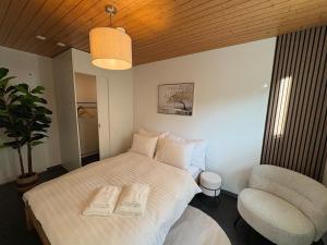 a bedroom with a white bed and a chair at Alpine Loft in Interlaken