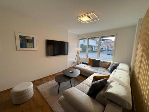 a living room with a couch and a tv at Alpine Loft in Interlaken