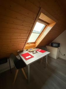 Ferienwohnung Hänel في Antonshöhe: غرفة مع طاولة ونافذة في العلية +22 صورة