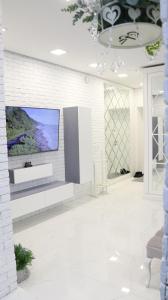sala de estar con TV en una pared de ladrillo blanco en Heart of Chișinău, en Chişinău