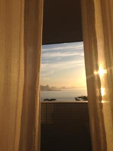 una finestra con vista sull'oceano di Guaruja Apartment a Guarujá