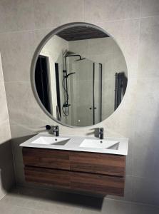 a bathroom with a white sink and a mirror at LyNora Lodge  +25 photos