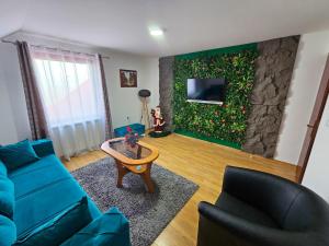 a living room with a blue couch and a stone wall at Apartmani NINA Zlatar in Nova Varoš