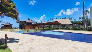 a swimming pool in front of a house at Atlântico Carneiros - Pé na areia no melhor trecho da Praia dos Carneiros in Praia dos Carneiros