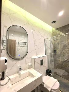 een badkamer met een wastafel en een spiegel en een douche bij AL Hyatt Relax Hotel in Aqaba +20 foto's