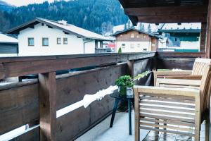 a balcony with two chairs and a table and a building at Dili Appartement in Altenmarkt im Pongau
