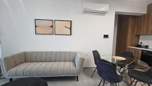 a living room with a couch and a table and chairs at STAY Engomi Gem 2 in İncirli