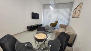a living room with chairs and a table and a tv at STAY Engomi Gem 2 in İncirli +16 photos