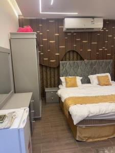 un dormitorio con una cama con cabecero en شاليه نخله, en Al Ula