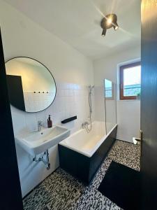a bathroom with a tub and a sink and a mirror at Apartment 22 in Schlins +37 photos