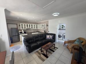 a living room with a black couch and a kitchen at Alvera in Strand