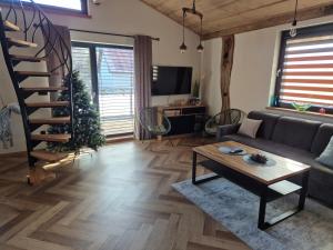 a living room with a couch and a spiral staircase at Luxusny apartman z tarasmi - Vera in Telgárt +20 photos
