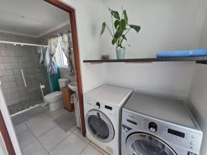 a laundry room with a washer and dryer in it at Alvera in Strand